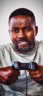 Frustrated man holding joystick against white background