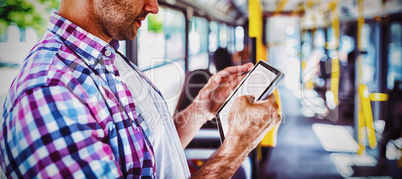 Handsome man looking at digital tablet in bus