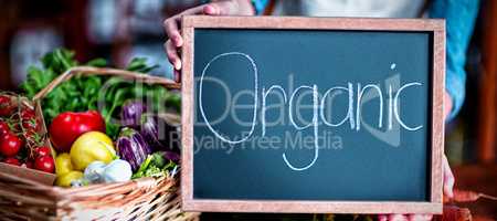 Female staff holding organic sign board