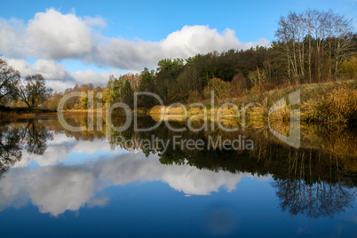 Autumn landscape with colorful trees and river. Reflection in ri