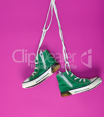 pair of green textile sneakers on white lace