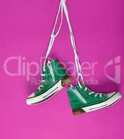pair of green textile sneakers on white lace