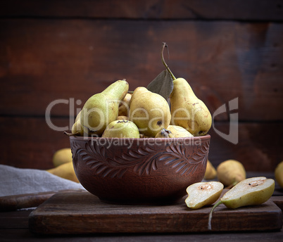 ripe green pears in a brown clay bowl