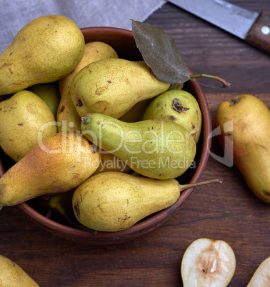 ripe green pears in a brown clay bowl
