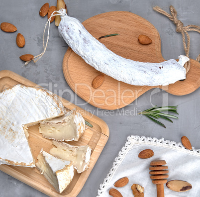 round piece of brie cheese and sausage on a wooden board