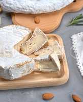 round brie cheese on a wooden cutting board