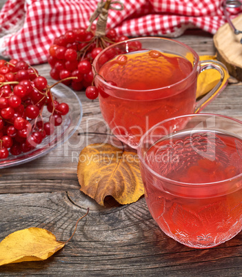 viburnum tea in a transparent cup on a gray wooden table