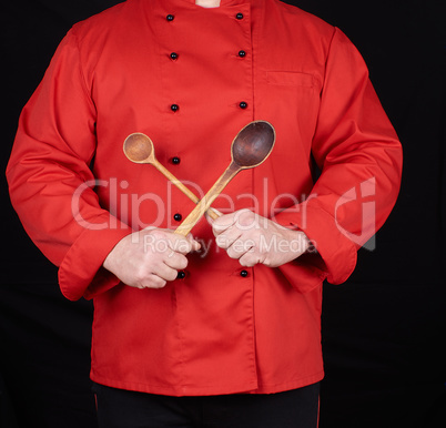 chef in red uniform holding old wooden spoons