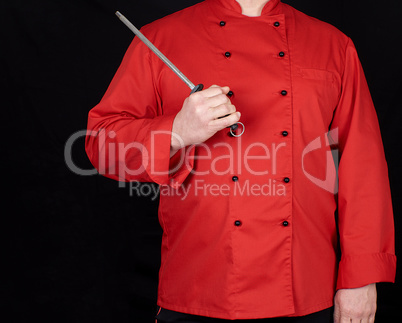 chef in red uniform holds knife sharpening tool