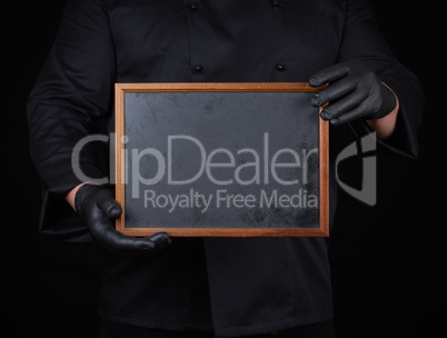 chef in black uniform  holds an empty wooden frame