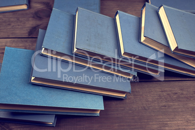 books in a blue cover on a brown wooden table