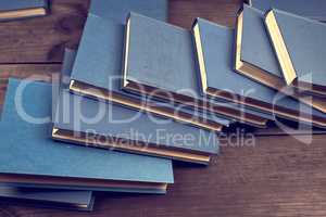 books in a blue cover on a brown wooden table