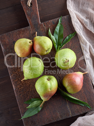 ripe green pears on a brown wooden board