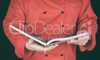 chef in red uniform holding open notepad