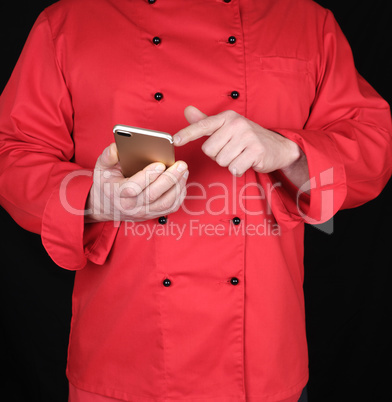 chef in red uniform holds in his hand a smartphone