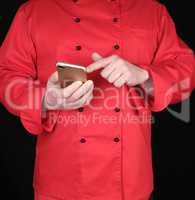 chef in red uniform holds in his hand a smartphone