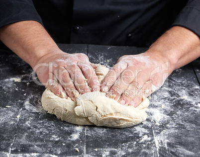 baker kneads white wheat flour dough