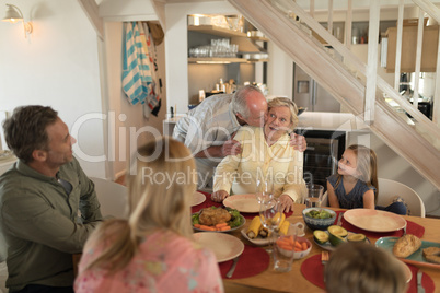 Senior man kissing her wife on dining table