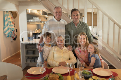 Family posing together before having meal on dining table