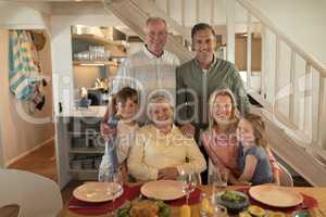 Family posing together before having meal on dining table
