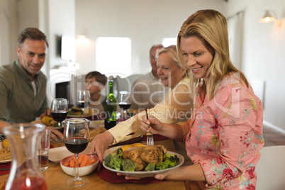 Family eating, smiling woman take food at home