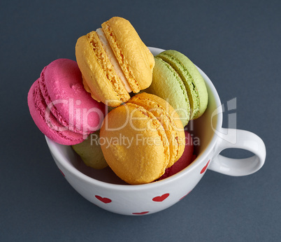 multicolored baked cakes of almond flour macarons in a white cer