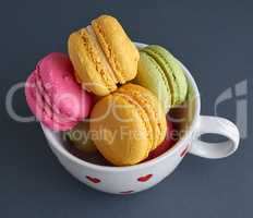 multicolored baked cakes of almond flour macarons in a white cer