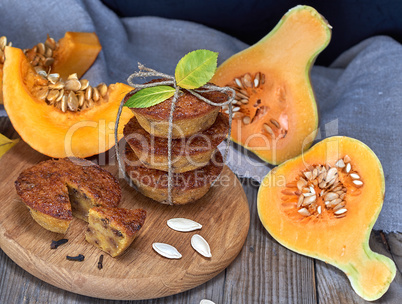 stack of muffins with a pumpkin on a round wooden board