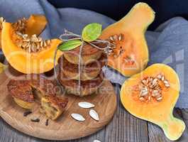 stack of muffins with a pumpkin on a round wooden board