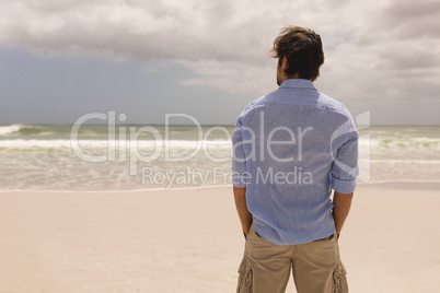 Man standing with hands in pocket on the beach