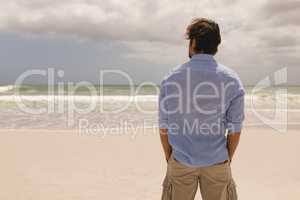 Man standing with hands in pocket on the beach