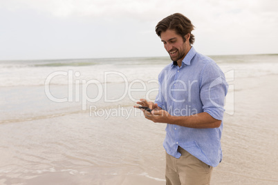 Man using mobile phone on the beach