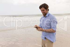 Man using mobile phone on the beach