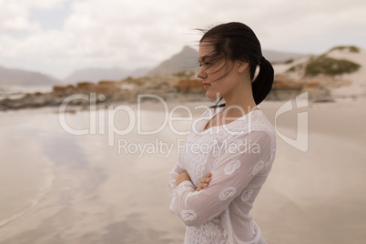 Woman standing with arms crossed on the beach