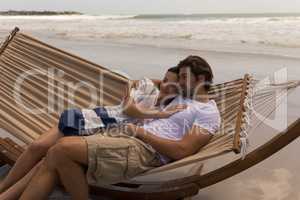 Young couple relaxing on hammock at beach