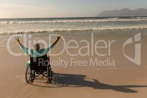 Disabled senior man with arms outstretched on the beach