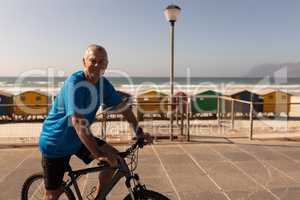 Senior man riding a bicycle on a promenade at beach