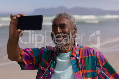 Senior man taking selfie with mobile phone on beach