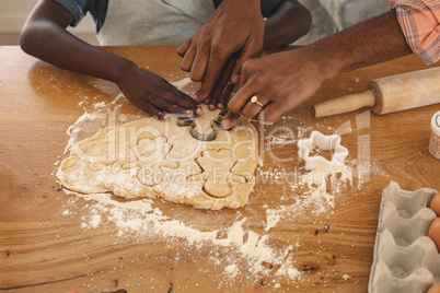 African American father and son baking cookies in kitchen