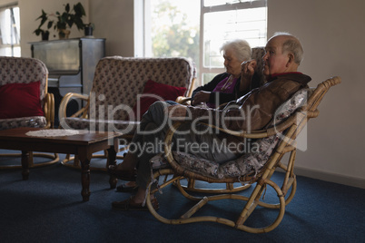 Senior couple relaxing on chair at nursing home