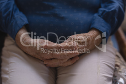 Senior woman with hands clasped at nursing home