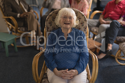 Front view of senior woman with hand clasped looking at camera in nursing home