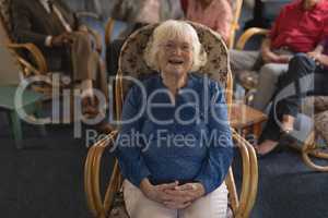Front view of senior woman with hand clasped looking at camera in nursing home