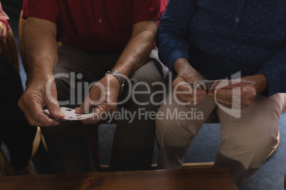 Senior men playing cards at home