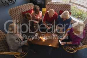 Group of senior friends playing cards at nursing home