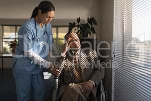 Female doctor consoling sad disable senior man at nursing home
