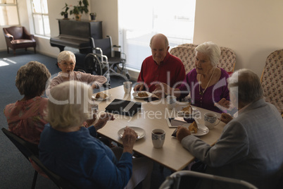 High angle view of group of senior friends having breakfast on dining table