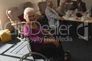 Side view of disable senior woman sitting on wheel chair and looking at camera