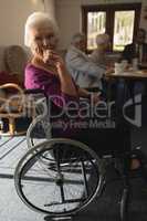 Side view of disable senior woman sitting on whee chair and looking at camera