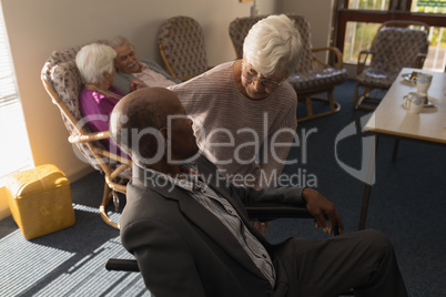 Senior woman talking with disable senior man at nursing home